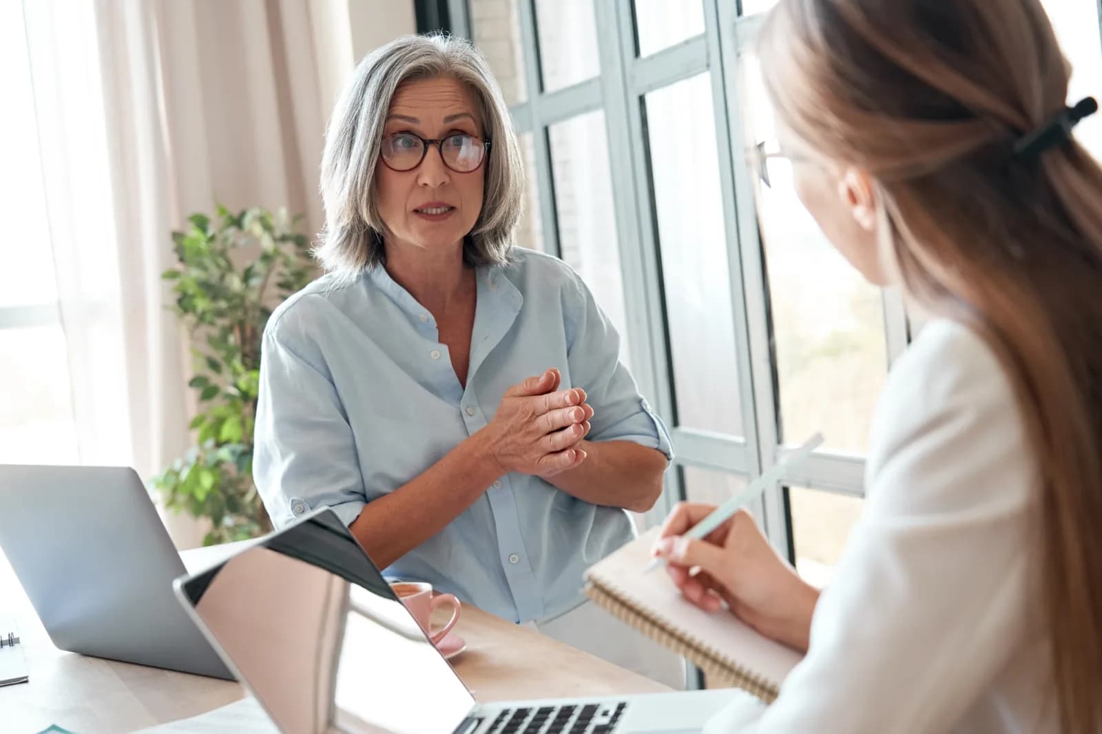 Concerned senior woman talking to another woman