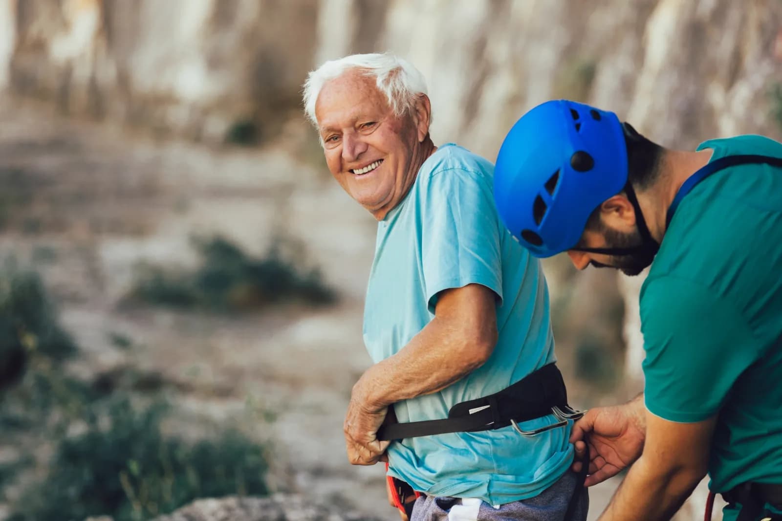 Happy senior man rock climbing