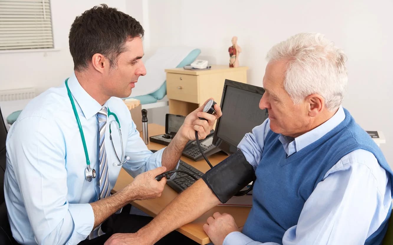 Doctor monitoring blood pressure on elderly patient