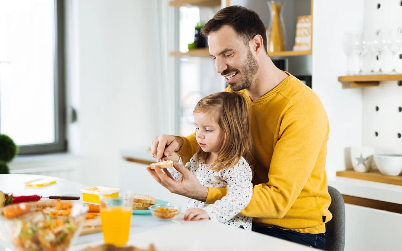 Father and toddler cooking in the kitchen making sandwiches