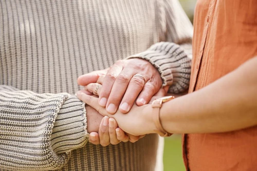 Two friends supporting each other holding hands