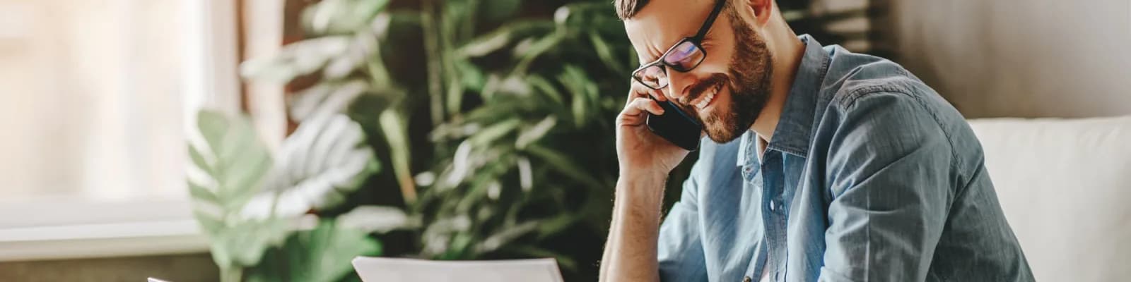 Man talking on the phone looking at paperwork