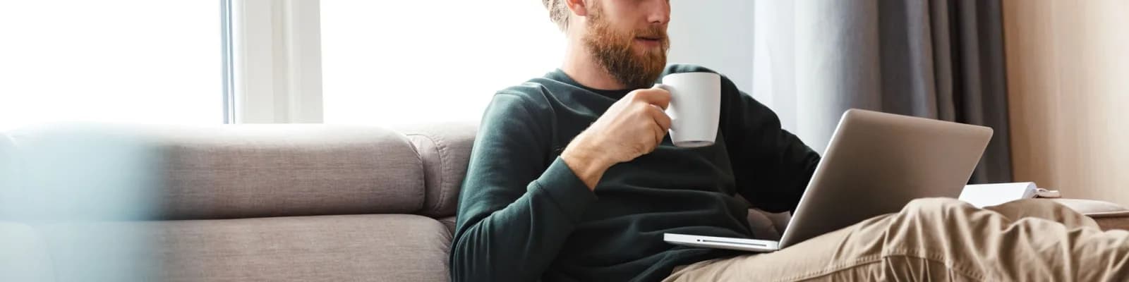 Man working on laptop drinking coffee