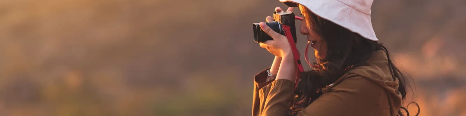 Woman looking through camera in the fields